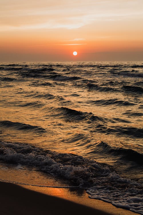 Ocean Waves Crashing on Shore at Sunset