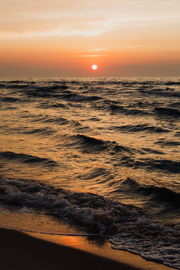 Ocean Waves Crashing On Shore At Sunset