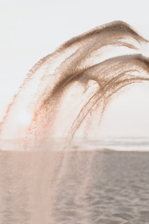 Splash of White Sand in the Air Near the Ocean