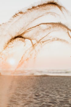 Artistic capture of sand splashing on a beach with a beautiful ocean sunset.