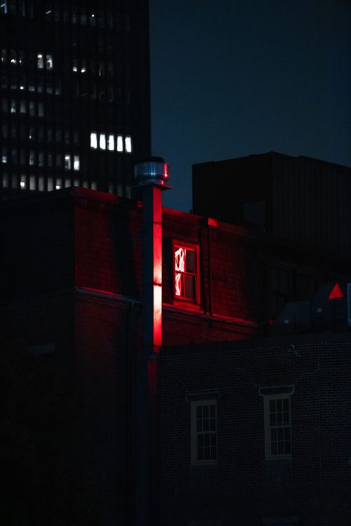 Free Eerie night scene of Boston building illuminated by red neon light creating a dramatic urban atmosphere. Stock Photo
