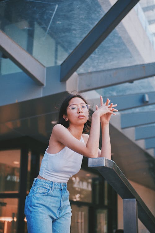 Photo of Woman in White Top Leaning on Handrail