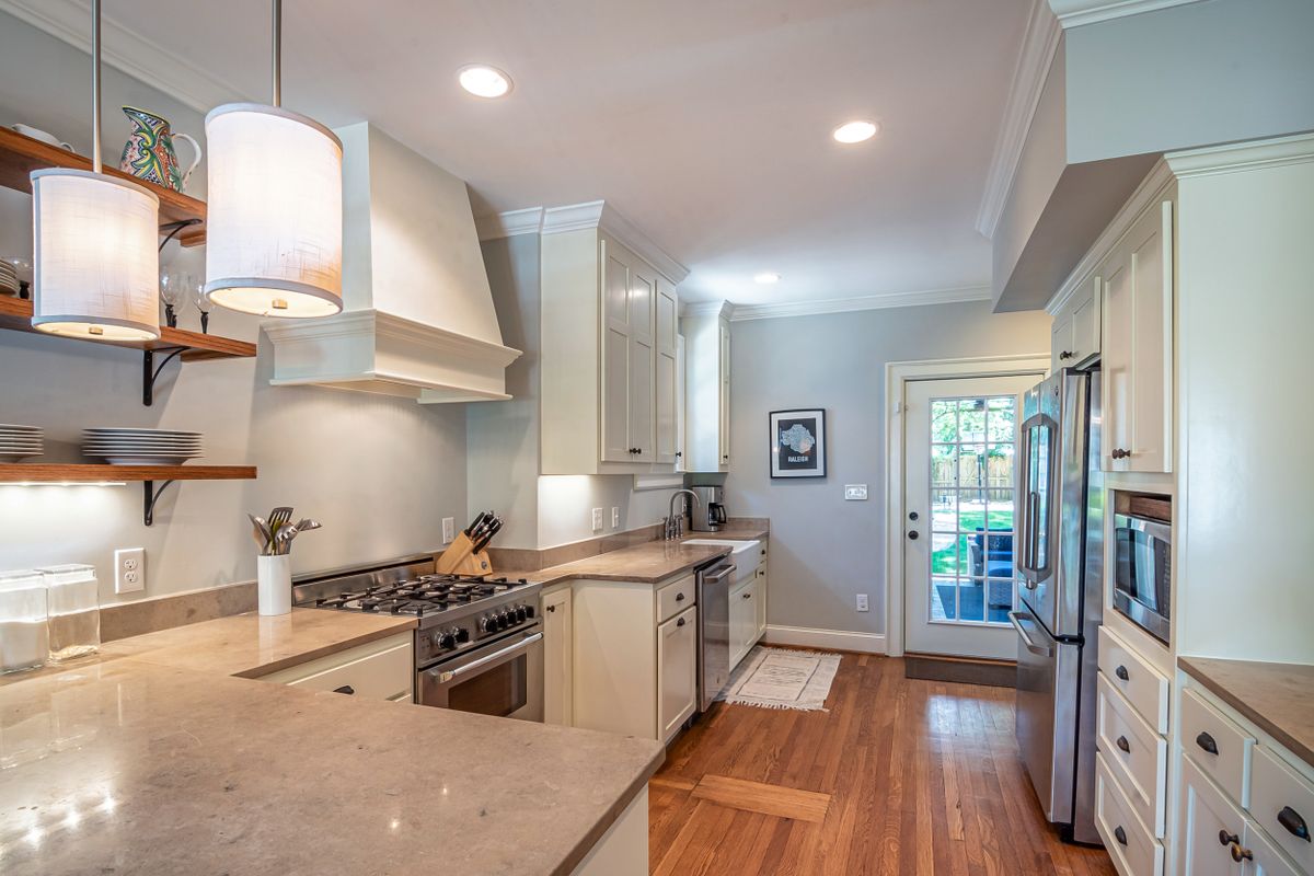A bright modern kitchen with wooden cabinets and open shelves for pantry organization ideas