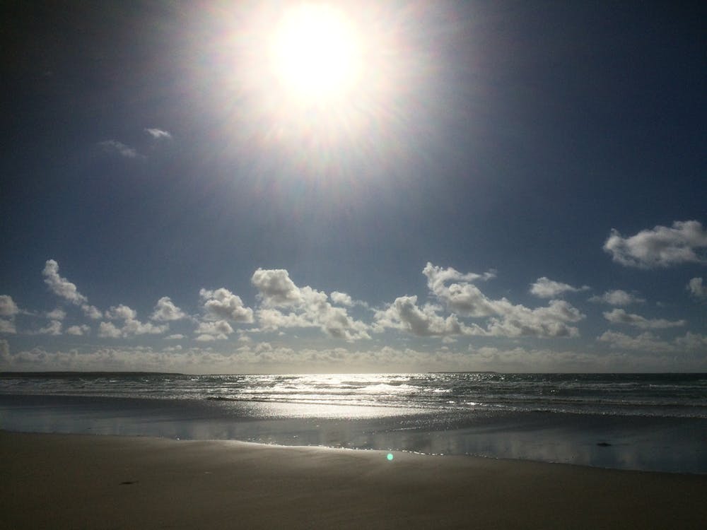 太陽の海と砂 眩しい太陽の無料の写真素材