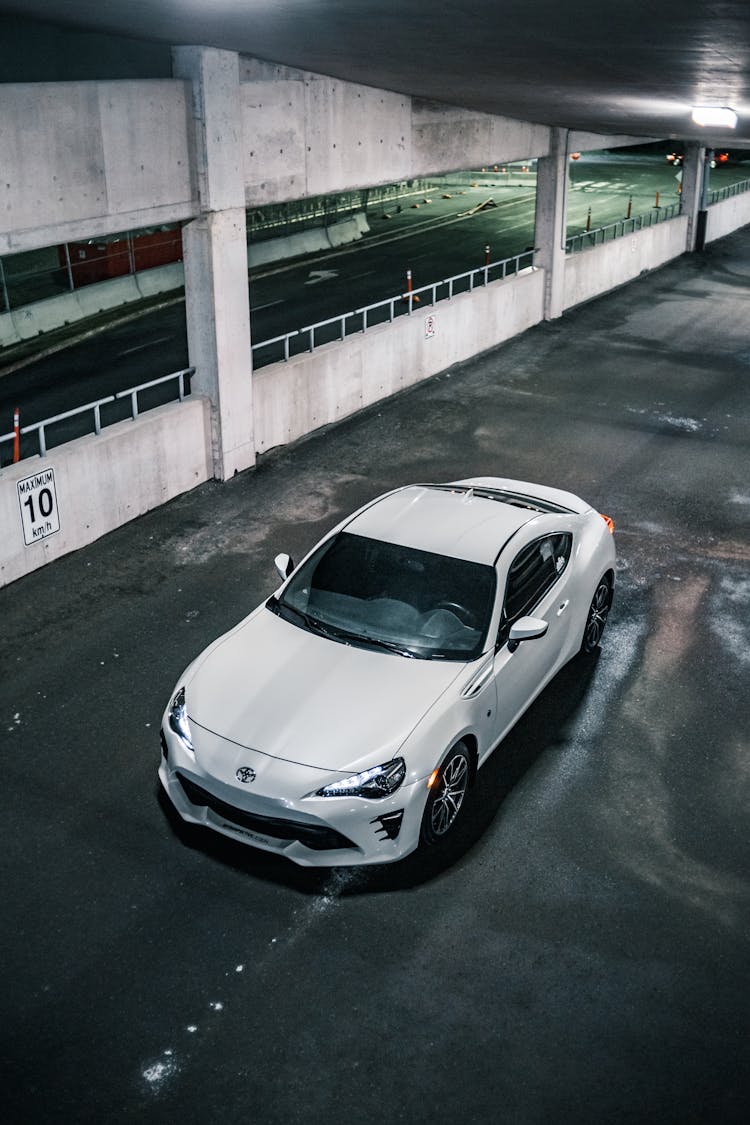 White Luxury Car With Bright Headlights Crossing Bridge