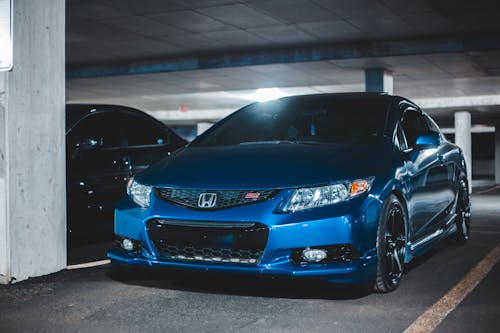 Modern design of bright car with stylish bumper and headlights parked on underground parking