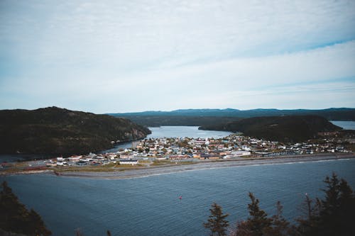 From above of housing complex between mounts and sea under cloudy sky in summer