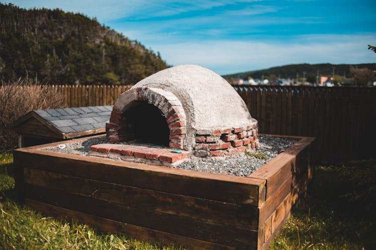 Old Brick Outdoor Oven Near Wooden Fence