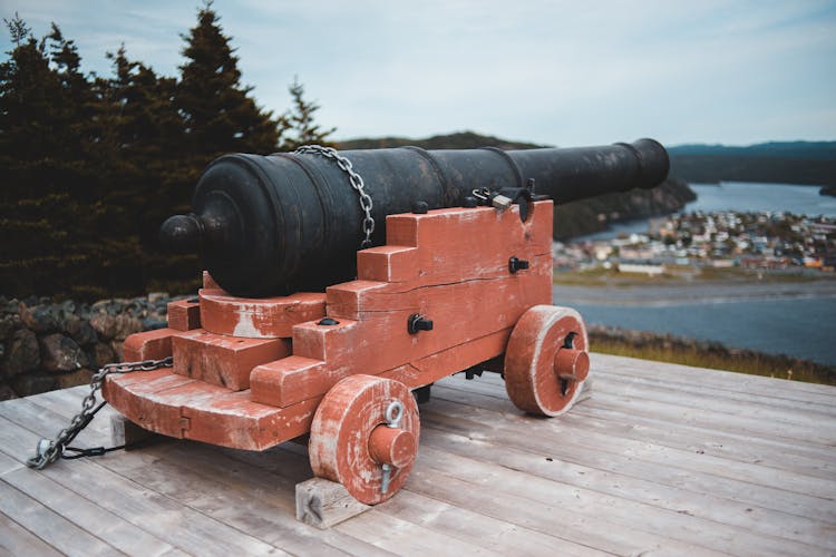 Old Ship Cannon On Wooden Platform Near Ocean