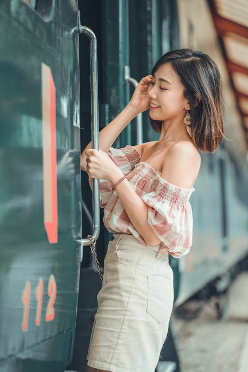Free Woman Fixing Her Hair While Entering a Train Stock Photo