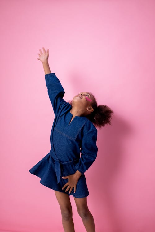 Woman in Blue Long Sleeve Shirt Raising Her Right Hand