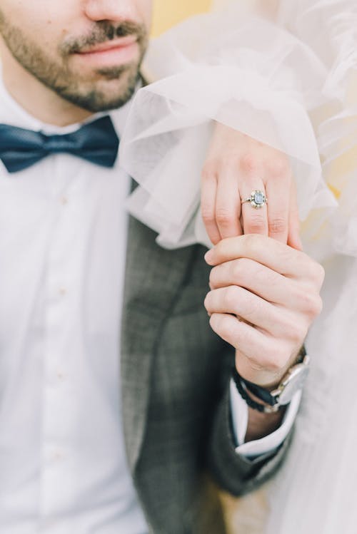 Groom Holding Hand of Bride with Engagement Ring