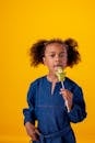 Woman in Blue Sweater Holding Yellow Flower