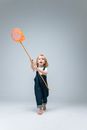 Girl in Blue Denim Dungaree Holding Orange Balloon