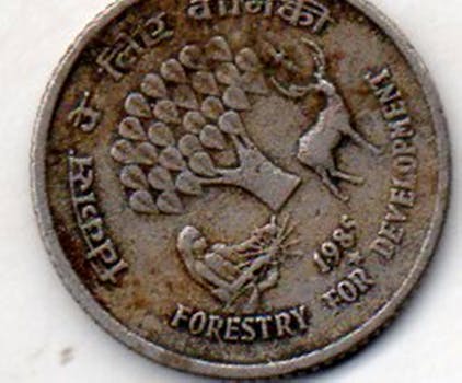Detailed close-up of a vintage Indian coin commemorating forestry development, dated 1985.