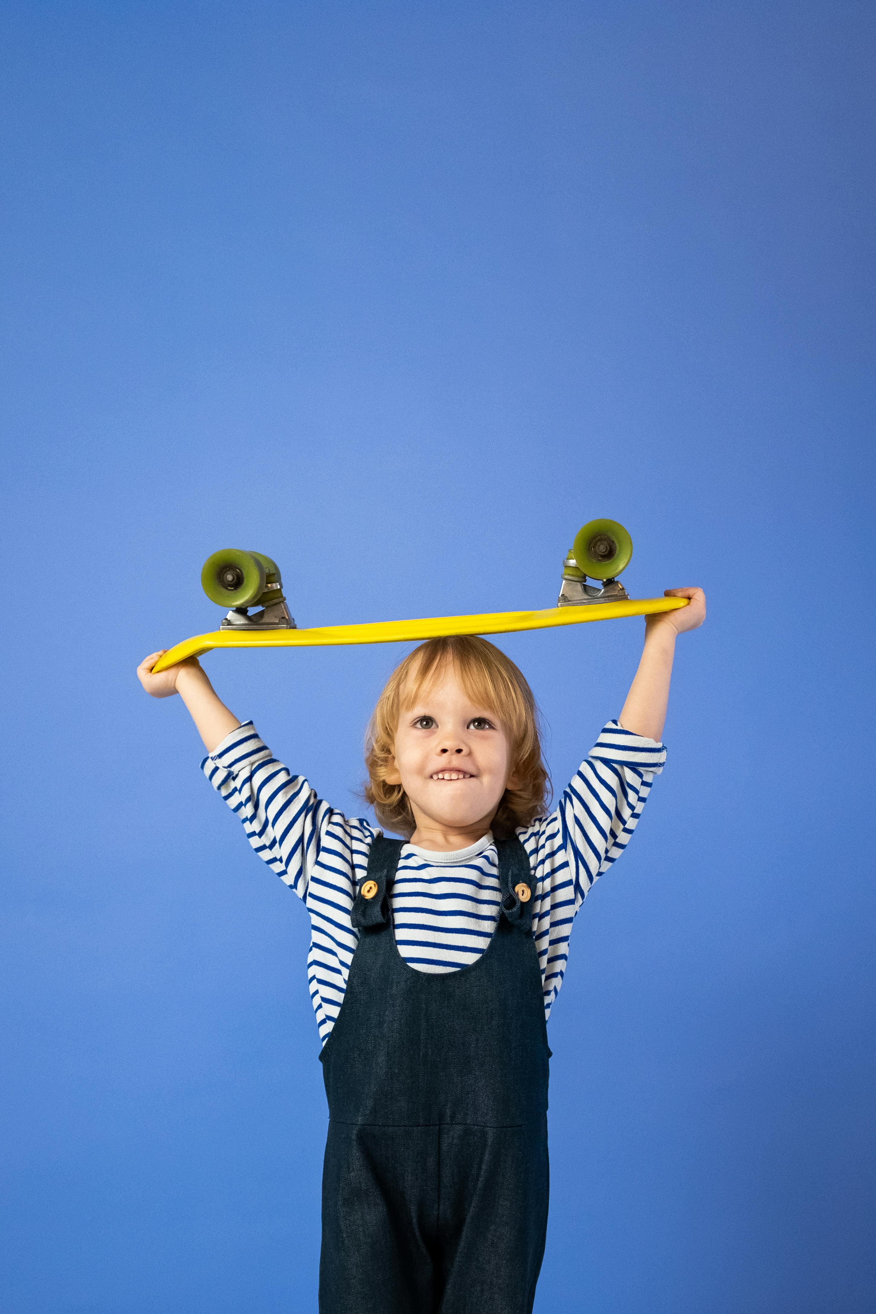 boy in white and black striped long sleeve shirt climbing on yellow ladder