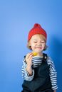 Boy in Red Knit Cap and Black and White Striped Shirt Eating Yellow Fruit