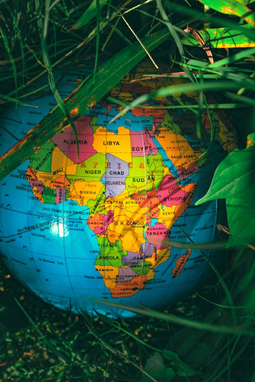 Globe with colorful map placed on grass in park