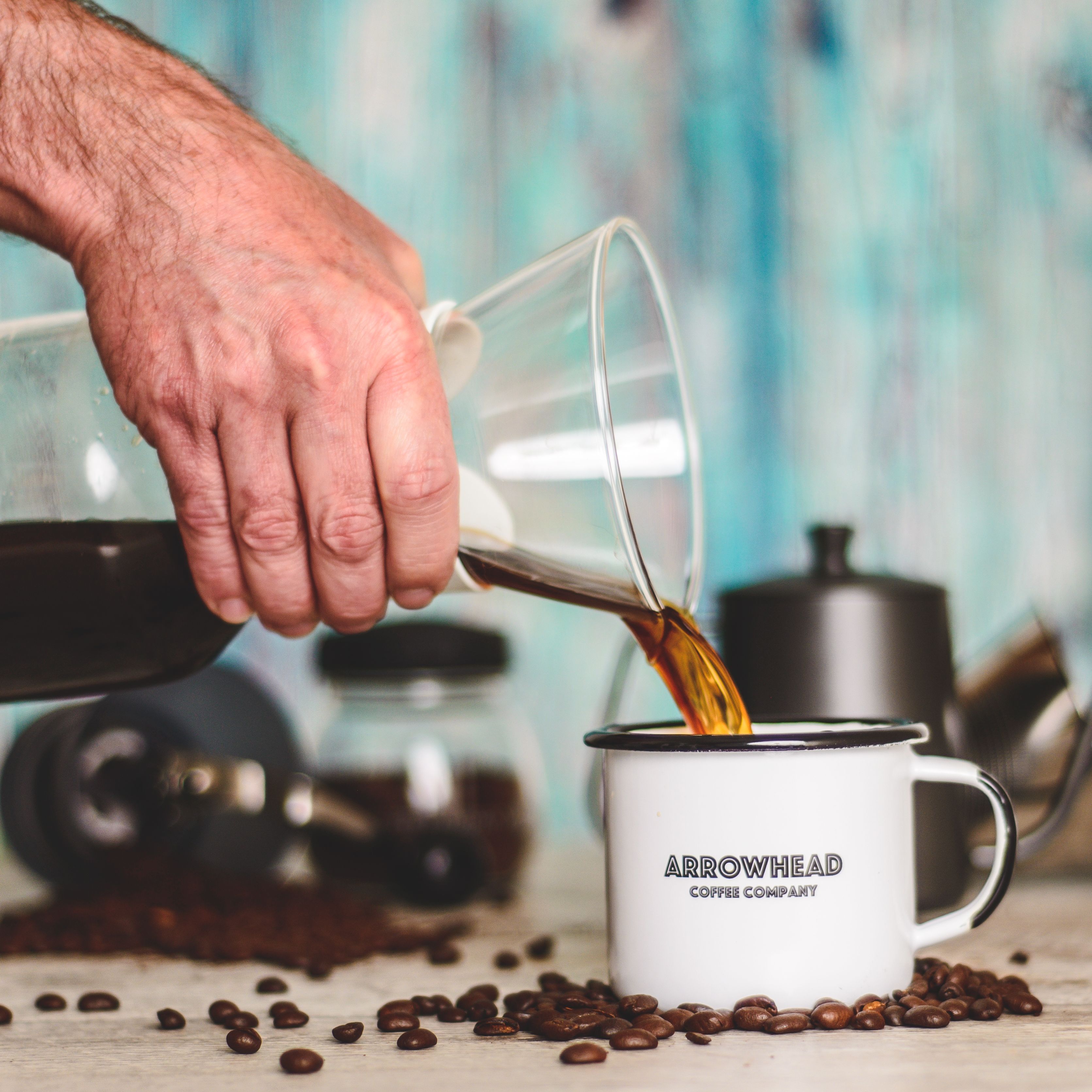 A Person Pouring Coffee on White Ceramic Mug
