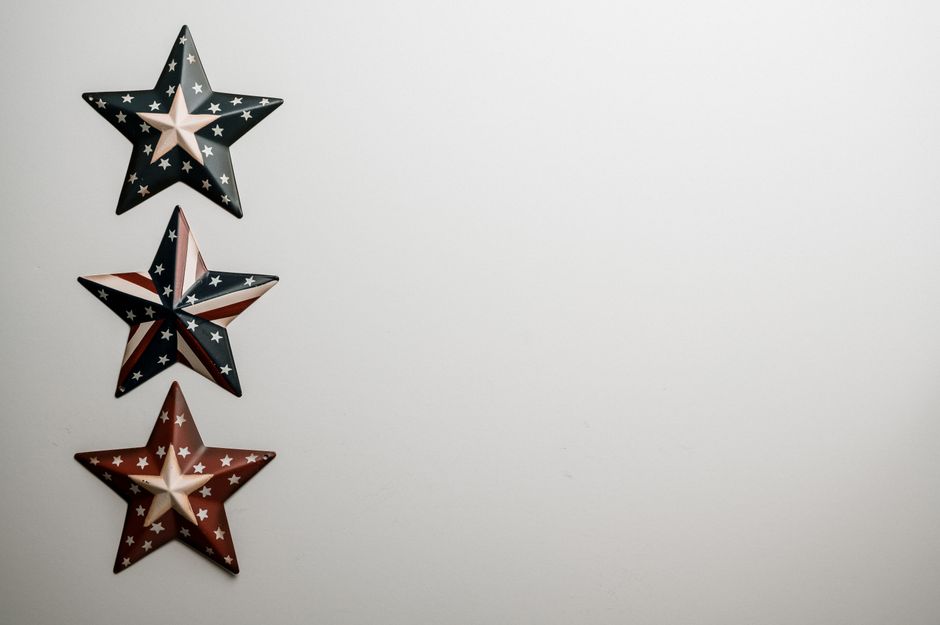 Top view of image of Flag of United Stated on surface of raised army stars on grey background