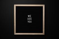 Chalkboard with white We See You inscription
