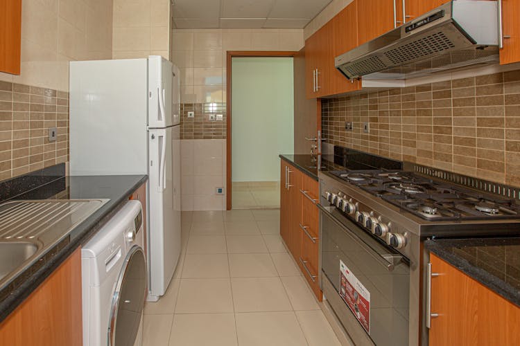 White Top Mount Refrigerator Beside White Dishwasher