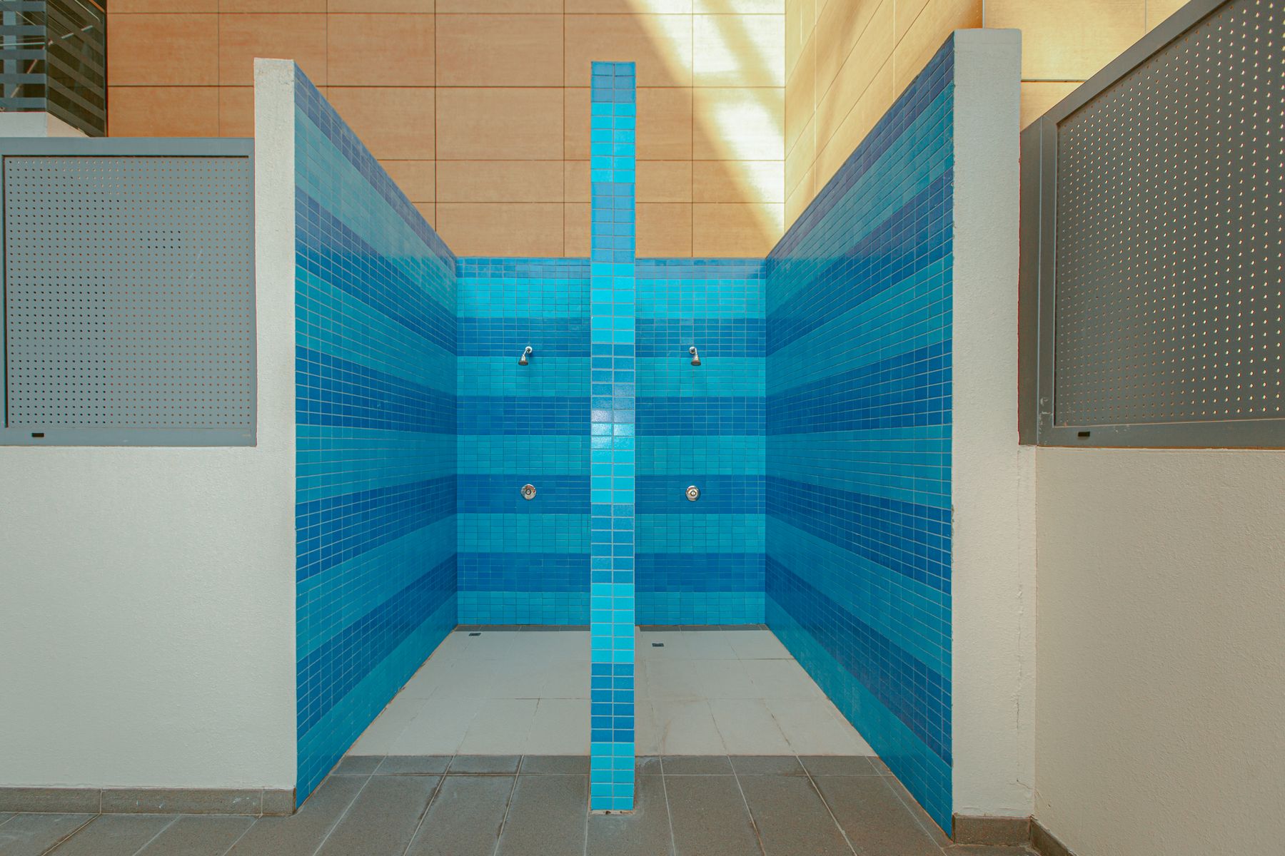 Modern shower area with vibrant blue tiled walls
