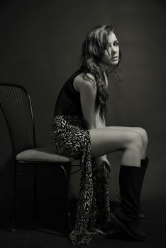 Elegant woman posing in a black and white studio setting, showcasing modern fashion.