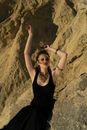 Stylish woman dancing on sandy terrain