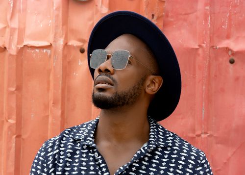 Free A fashionable man wearing sunglasses and a hat poses against a textured wall. Stylish and trendsetting. Stock Photo