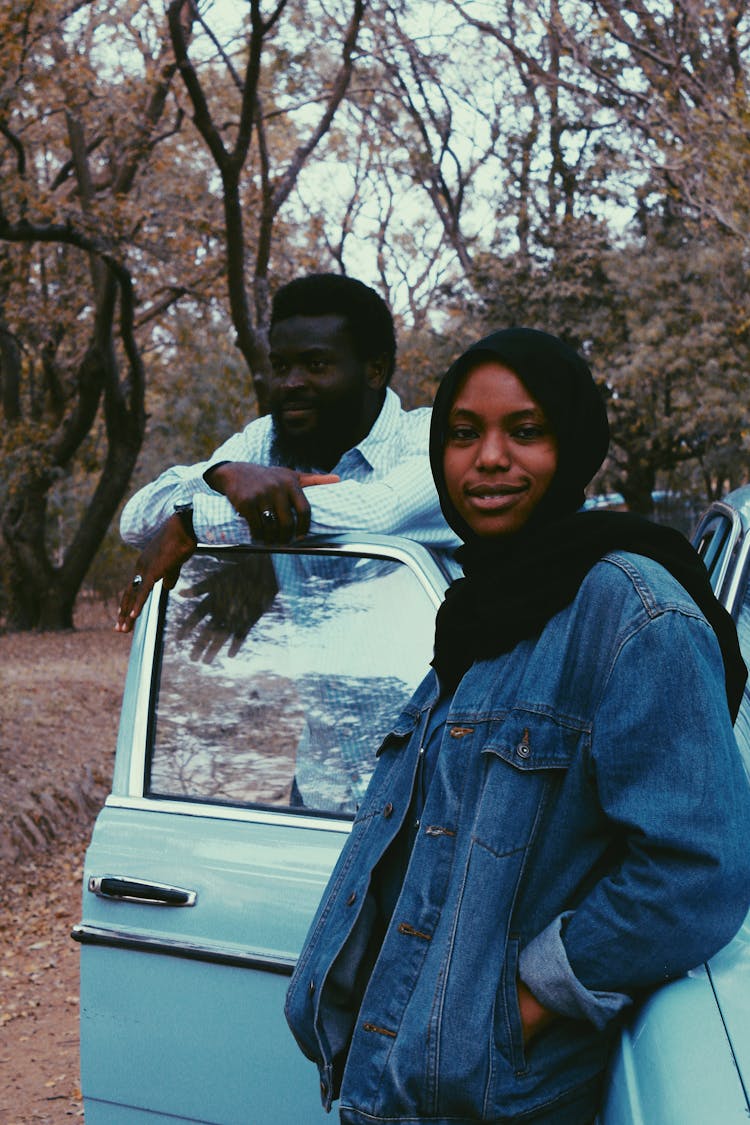 Black Couple Standing Near Retro Car In Forest