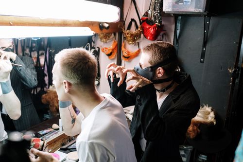 Free Diverse performers prepare with makeup and costumes in a vibrant dressing room. Stock Photo