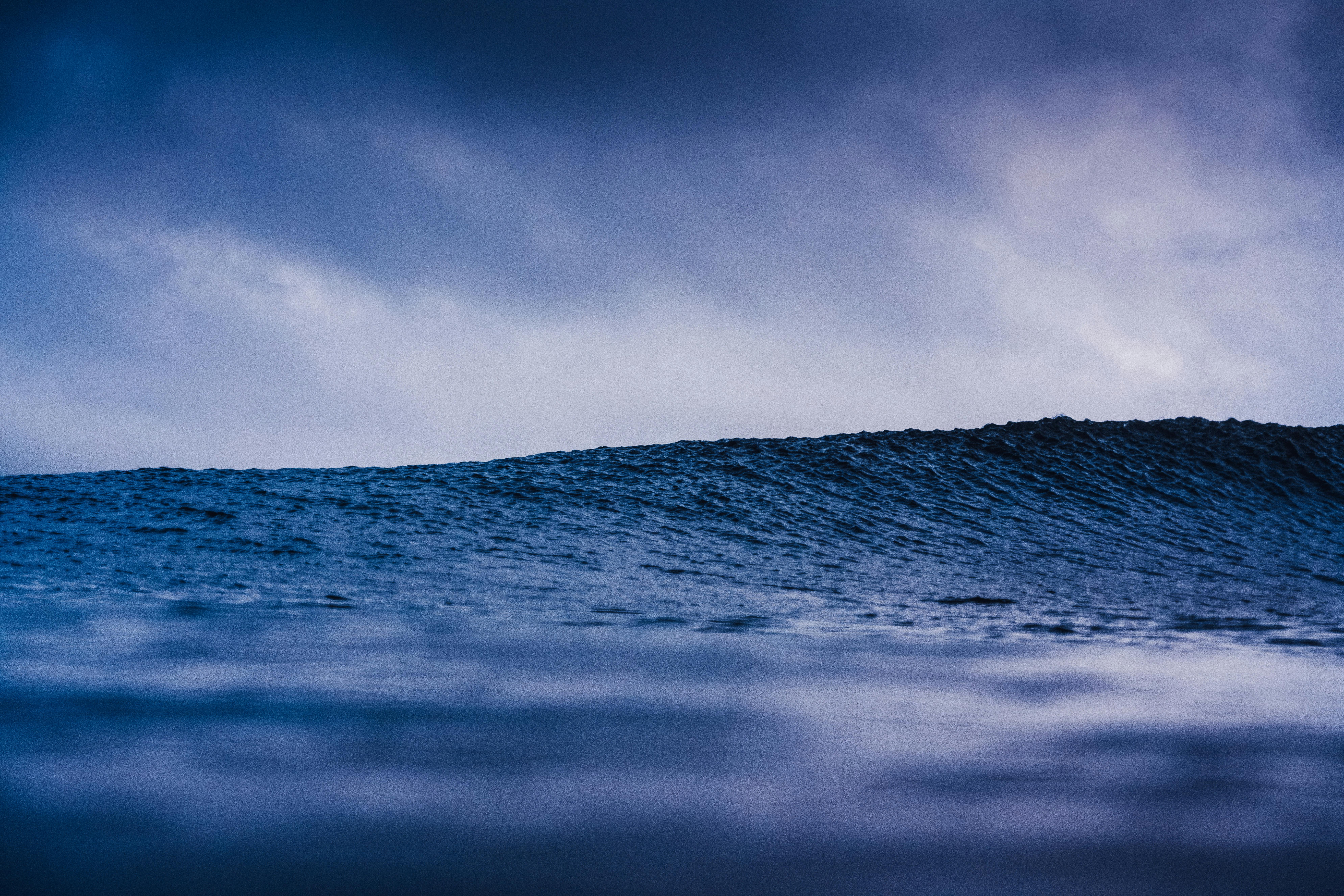 Rippling wavy water of breathtaking powerful blue ocean under sky with cumulus clouds