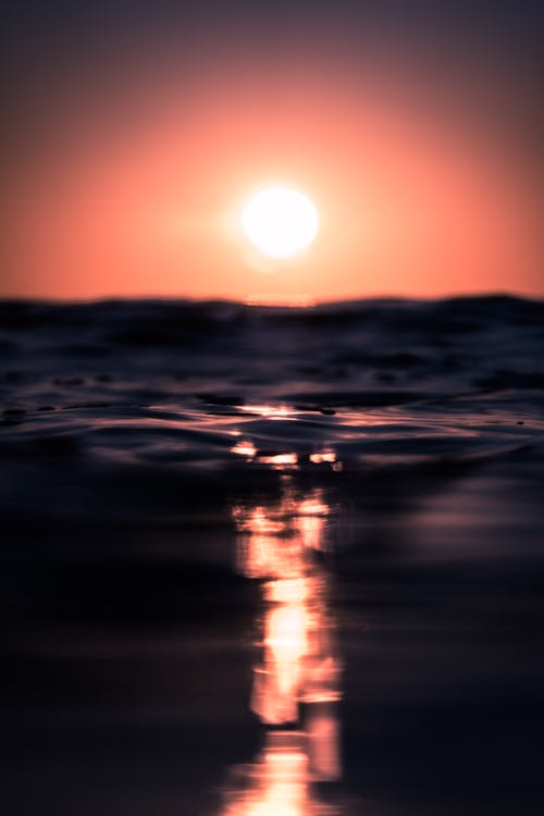 Free Picturesque view of water surface of rippled ocean against red sky in sundown Stock Photo