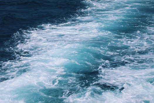 Dynamic capture of ocean waves with bright blue and white hues, showcasing natural beauty.
