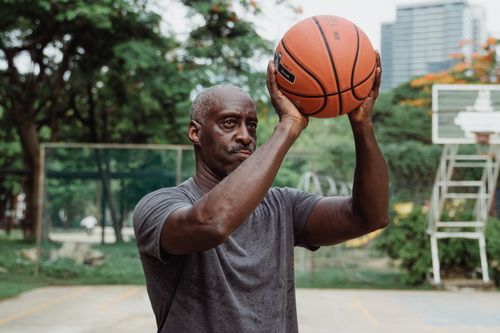 Free A senior African American man playing basketball in an outdoor court. Stock Photo