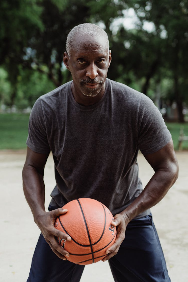 A Man In Gray Shirt Holding A Basketball