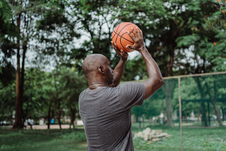 A Man In Gray Shirt Holding A Basketball