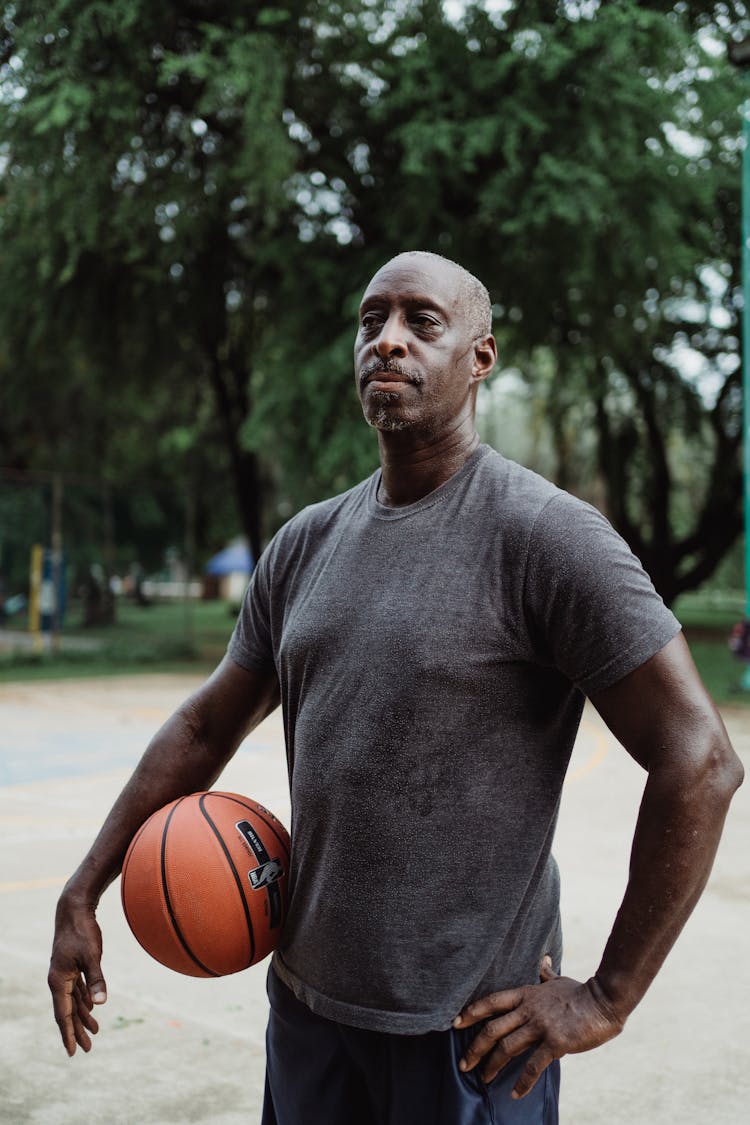 A Man In Gray Shirt Holding A Basketball