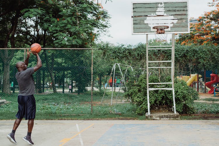 A Man In Gray Shirt Playing Basketball