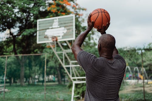 A Man in Gray Shirt Playing Basketball