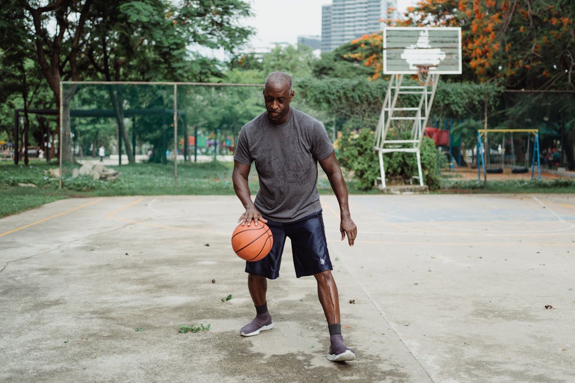 A Man in Gray Shirt Playing Basketball