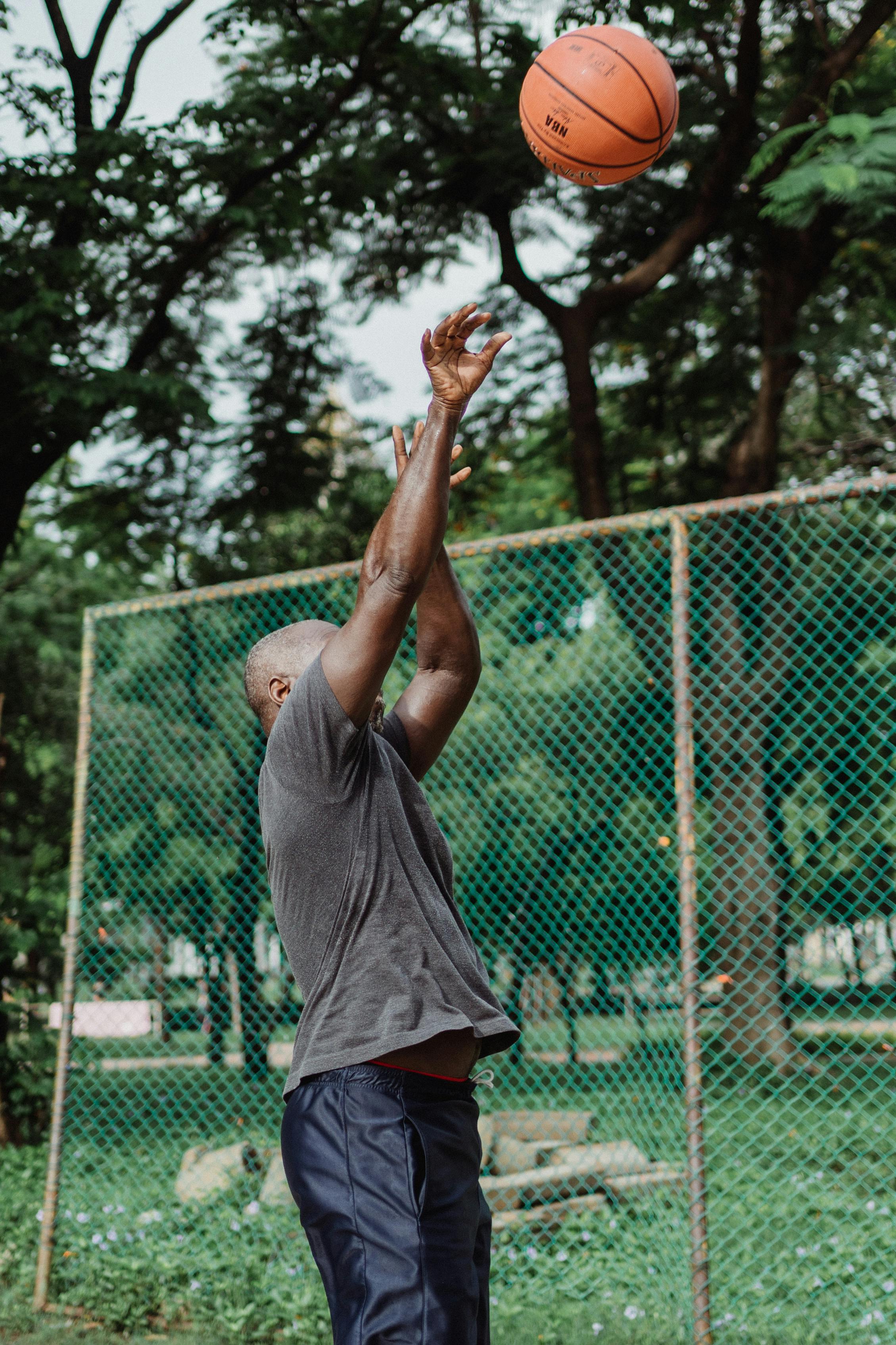 a man in gray shirt playing basketball