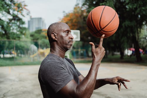 Man in Gray Crew Neck T-shirt Holding Basketball