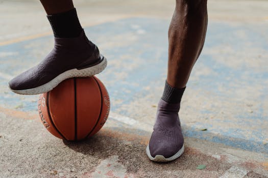 A close-up of a basketball player balancing on a ball with stylish athletic shoes.