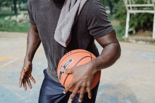 Dynamic close-up of a basketball player dribbling on an outdoor court.