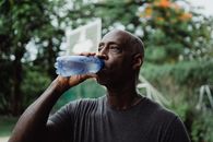 Man in Gray Crew Neck Shirt Drinking Water