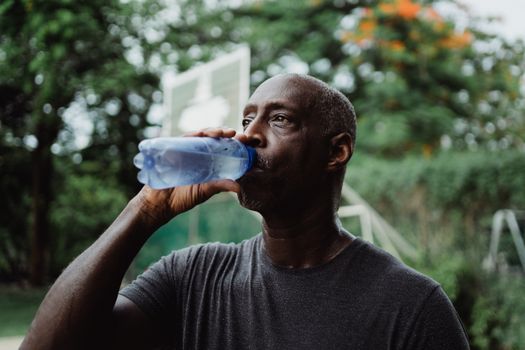 Man in Gray Crew Neck Shirt Drinking Water