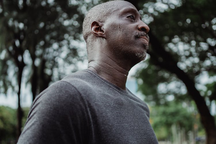 Man Walking Outside With Sweat Dripping Down His Forehead 