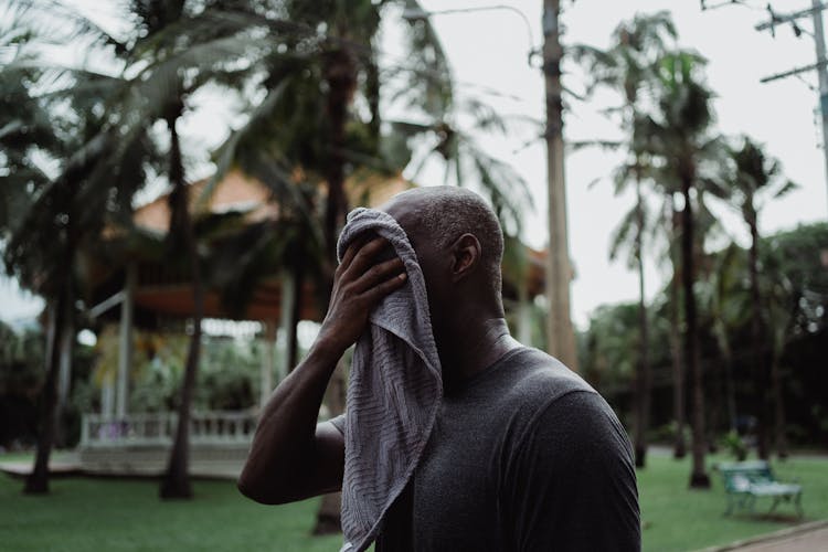 Man Wiping His Face With A Towel 